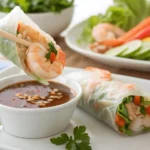 Shrimp spring roll dipped in sauce.